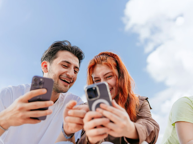 Couple smiling while using phones